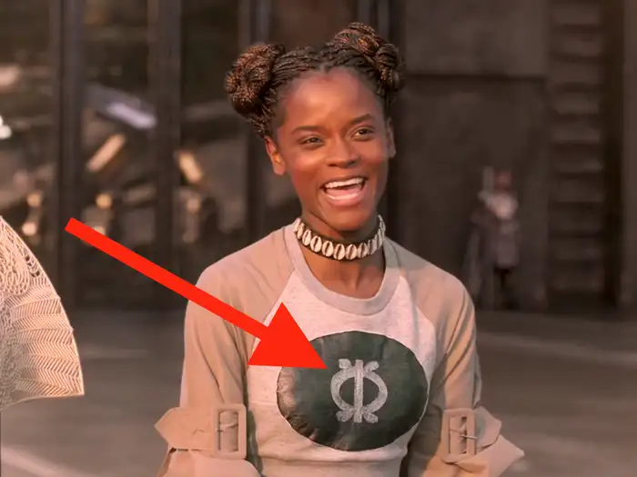 A picture of Shuri from black panther wearing the "Wawa" Adinkra Symbol. According to several online resources, it "literally means the 'seed of the wawa tree,' which is a symbol of hardness, toughness and perseverance.