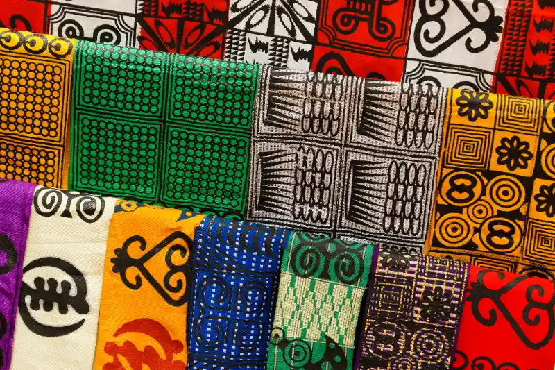 A picture of different textiles with Adinkra symbols on them.